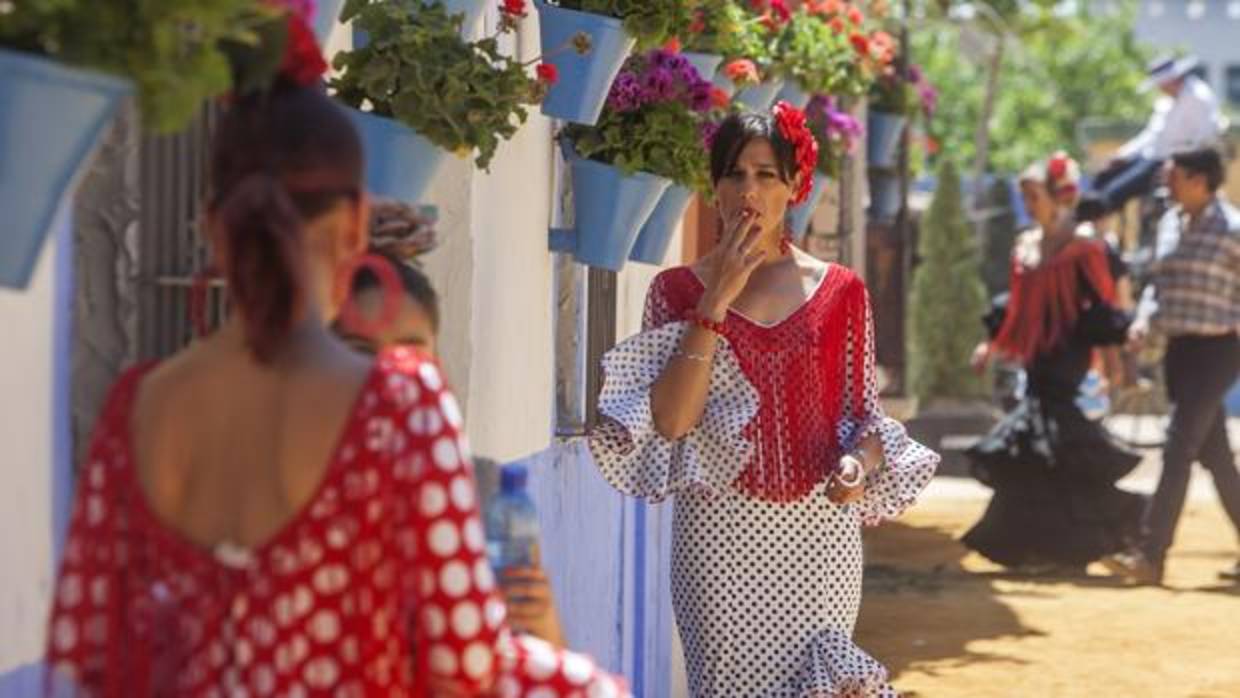 Una joven fuma ante una caseta del recinto ferial de Córdoba