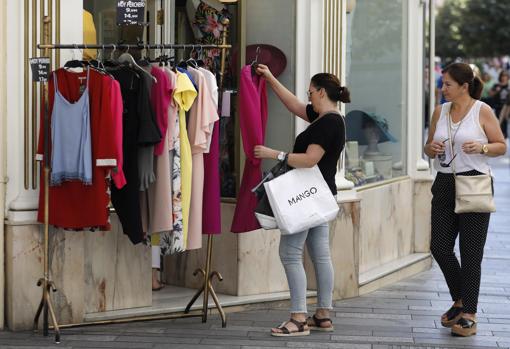 Algunas tiendas usan el perchero en la calle como reclamo