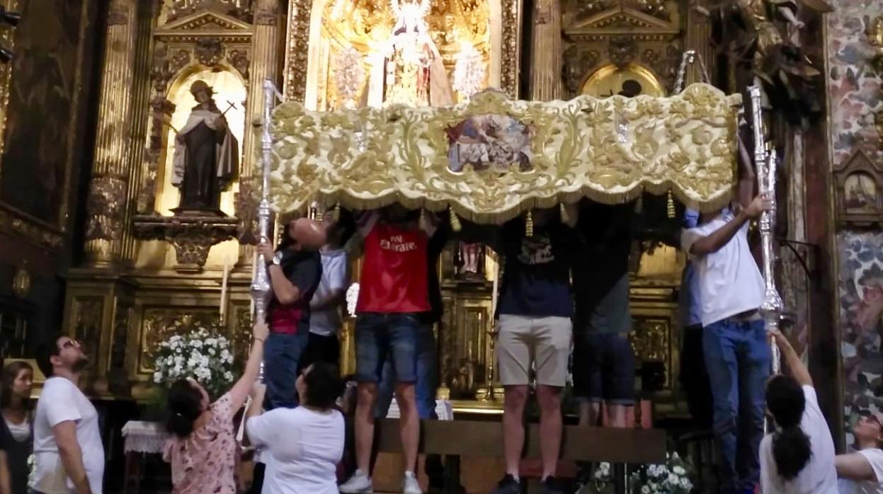 Miembros de la hermandad del Carmen colocando el palio
