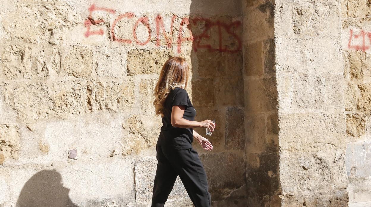 Una mujer pasa por delante de las pintadas en San Lorenzo