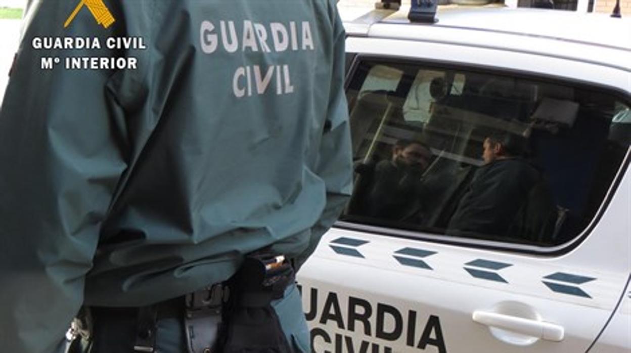 Imagen de un agente de la Guardia Civil junto a un vehículo