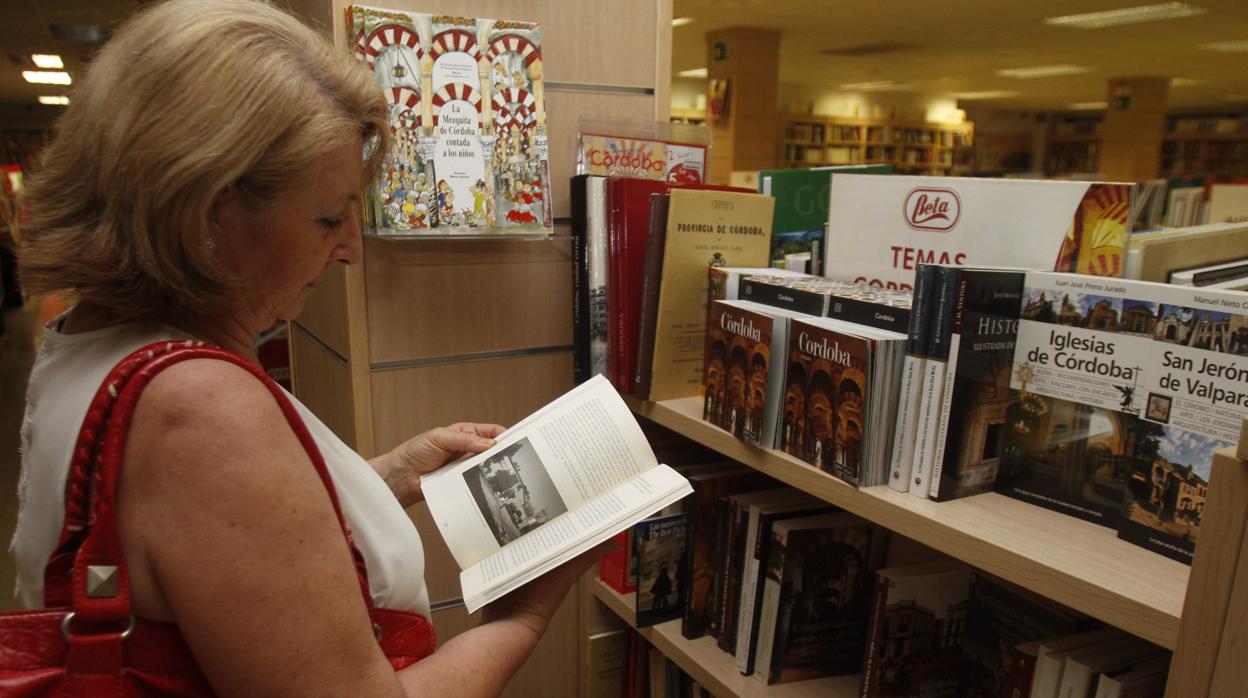 Una mujer lee un libro en una libreria