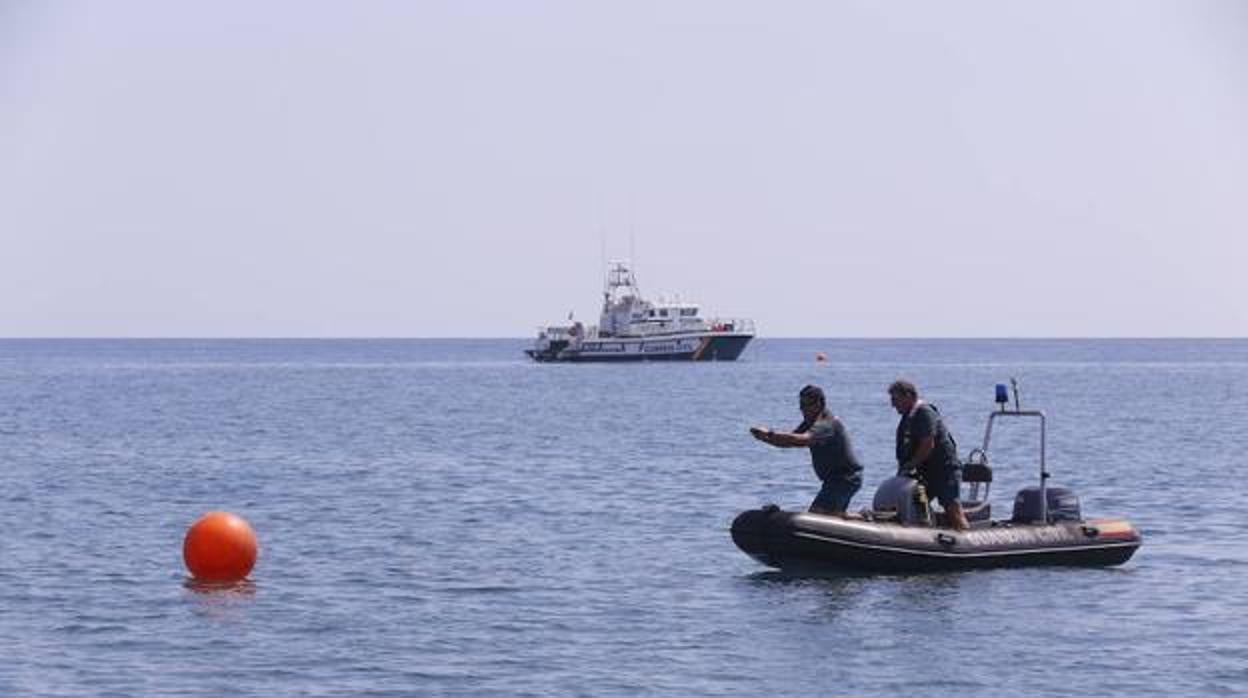 Dos agentes inspeccionan el mar en las inmediaciones de la zona donde estaba el cadáver
