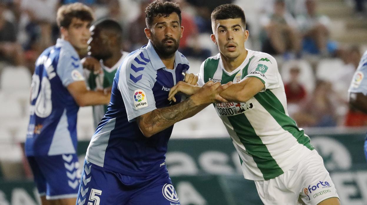 El central del Córdoba Alex Quintanilla pelea por un balón con un zaguero del Tenerife