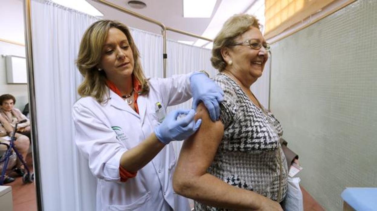 Una mujer se vacuna contra la gripe en un centro de salud