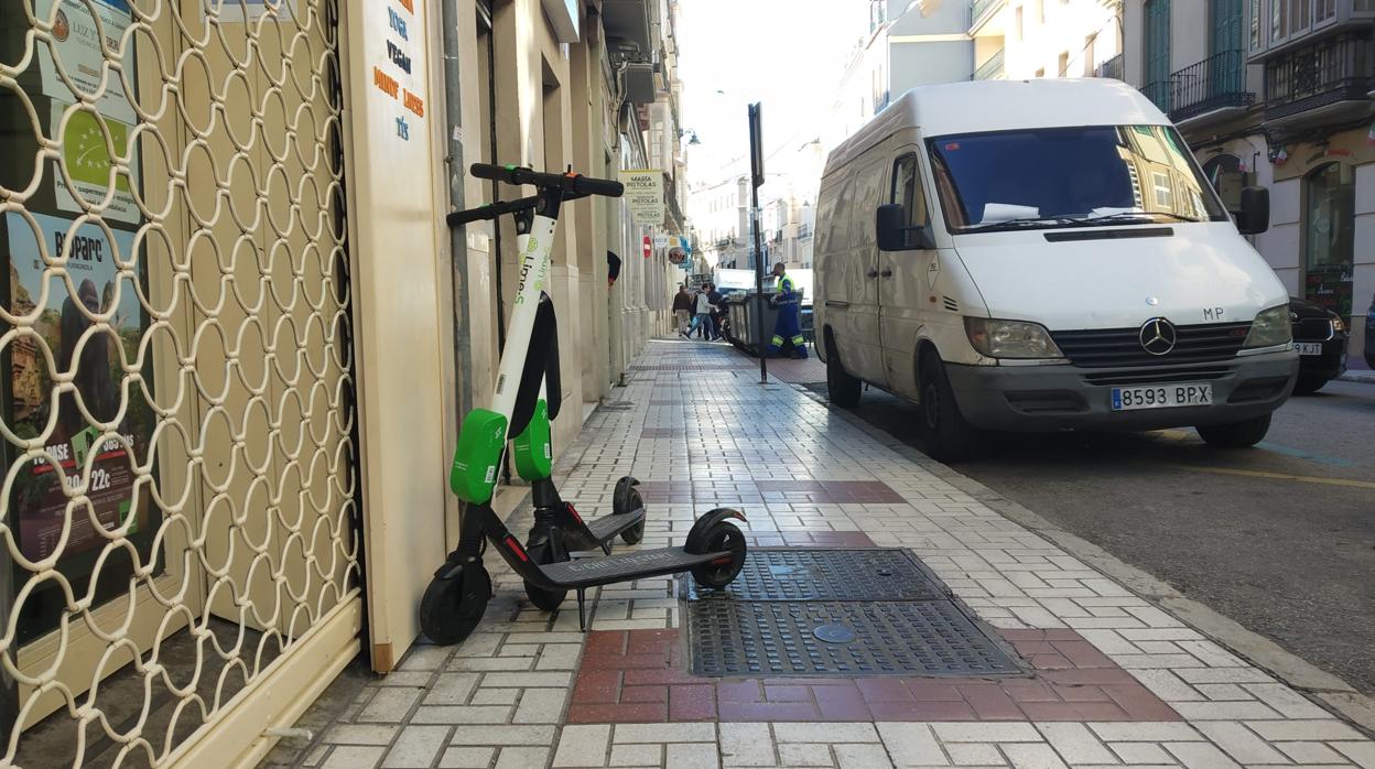 Dos patinetes eléctricos en mitad de la acera