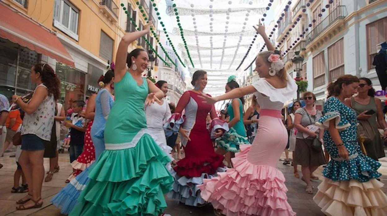 Mujeres bailando durante en la Feria de Agosto en plena calle Larios