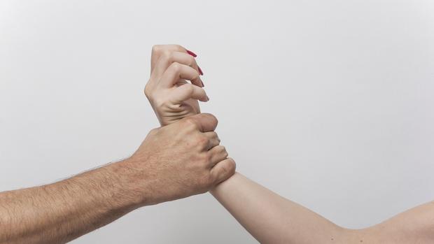 Un hombre agarra el brazo de una mujer