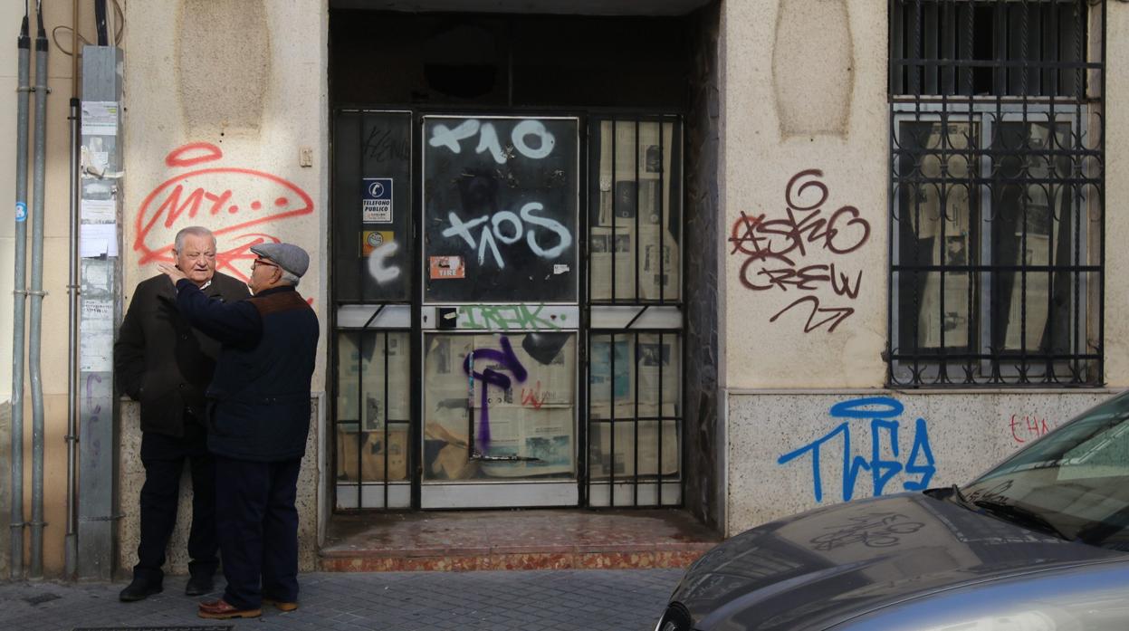 Dos vecinos de Ciudad Jardín ante un local cerrado y con pintadas