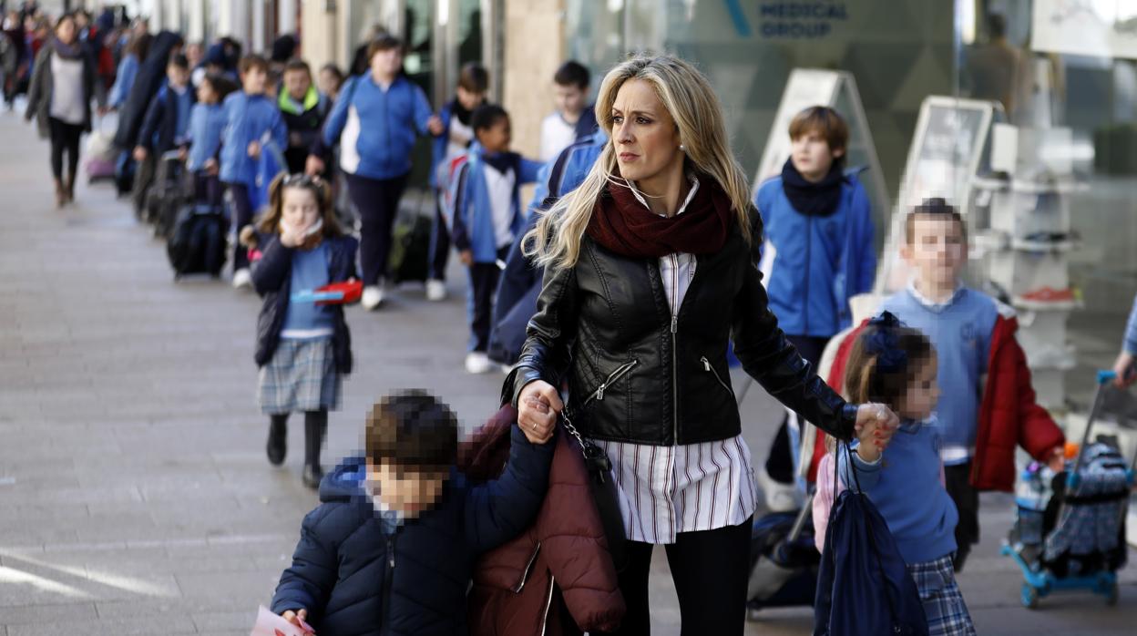 Una monitora de «Camino al cole» lleva a los niños al punto de recogida