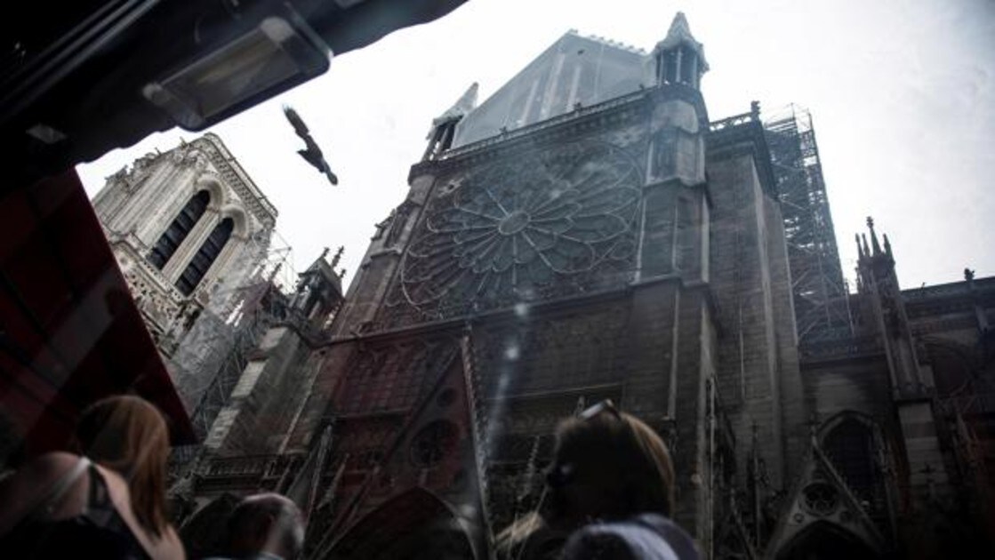 Turistas caminan junto a la catedral de Notre Dame tras el incendio