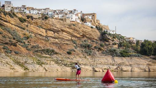 Un surfista en el pantano con la localidad de Iznájar al fondo