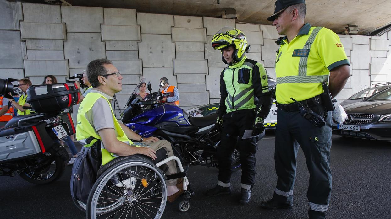 Un voluntario de Aspaym conversa con un motorista en un control de la Guardia Civil esta mañana