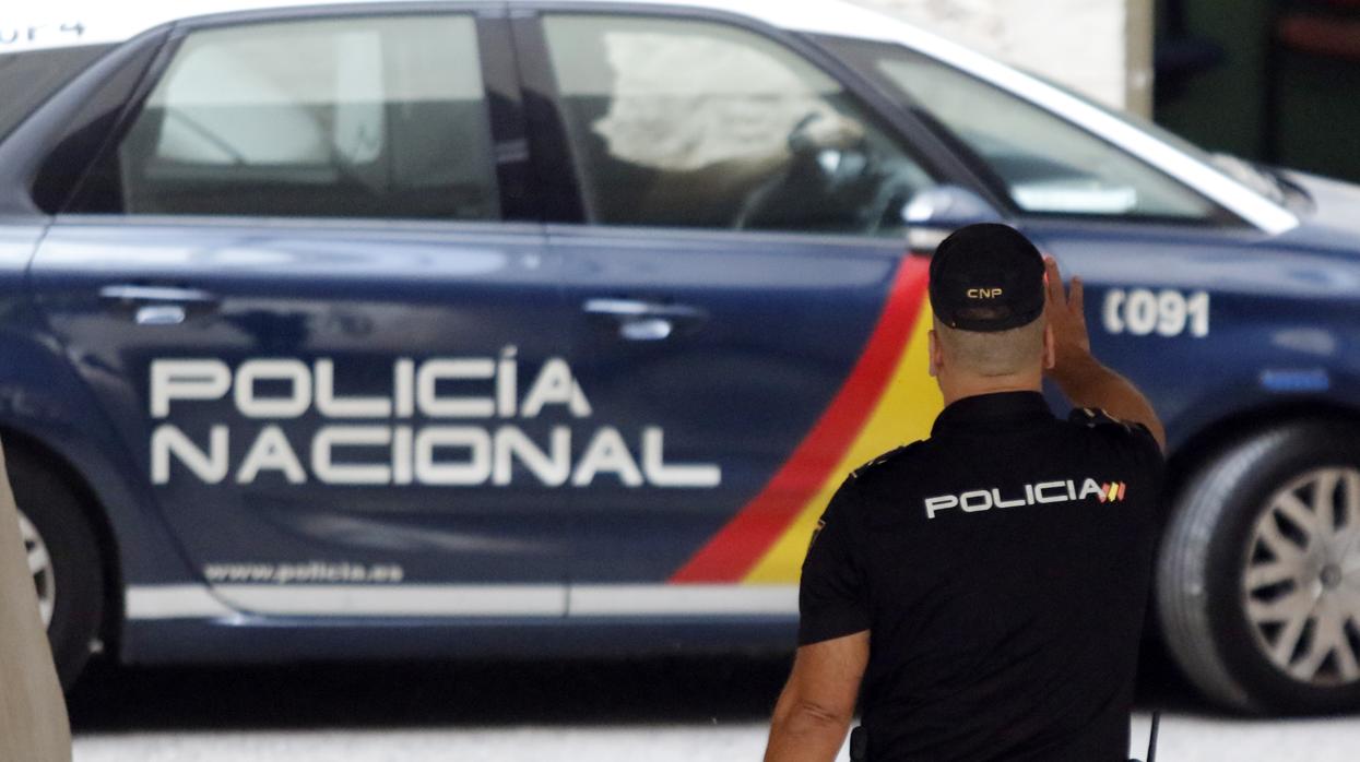 Un agente se dirige a un vehículo policial