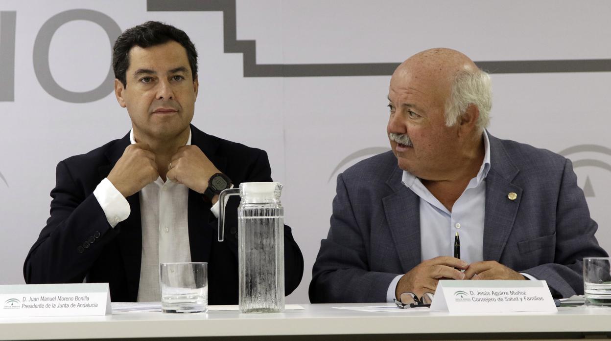 El presidente de la Junta Juanma Moreno, a la izquierda junto al consejero de Salud, denuncia la «asfixia» y el PSOE-A calla