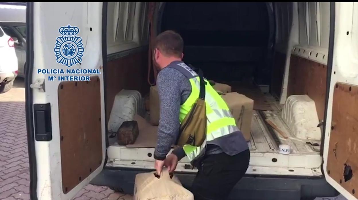 Un agente de la Policía Nacional descarga parte de la droga intervenida en esta operación