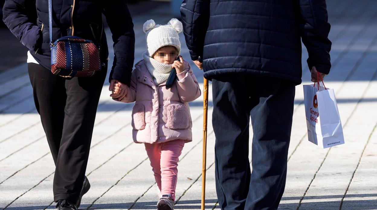 Una niña junto a un anciano por las calles