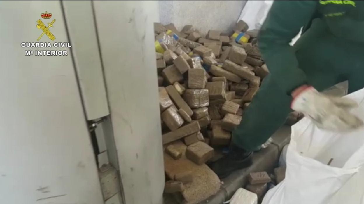 Un agente saca las pastillas de hachís halladas en el doble fondo del vehículo