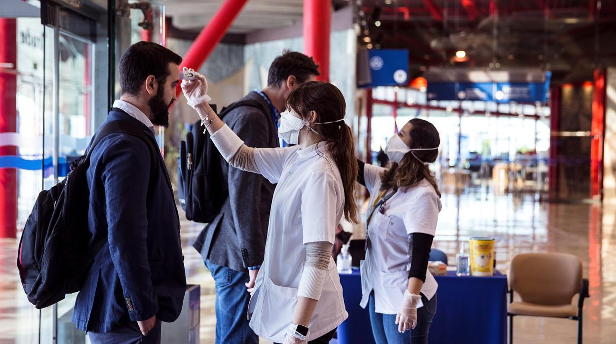 Dos sanitarias realizan pruebas a la entrada de un edificio público