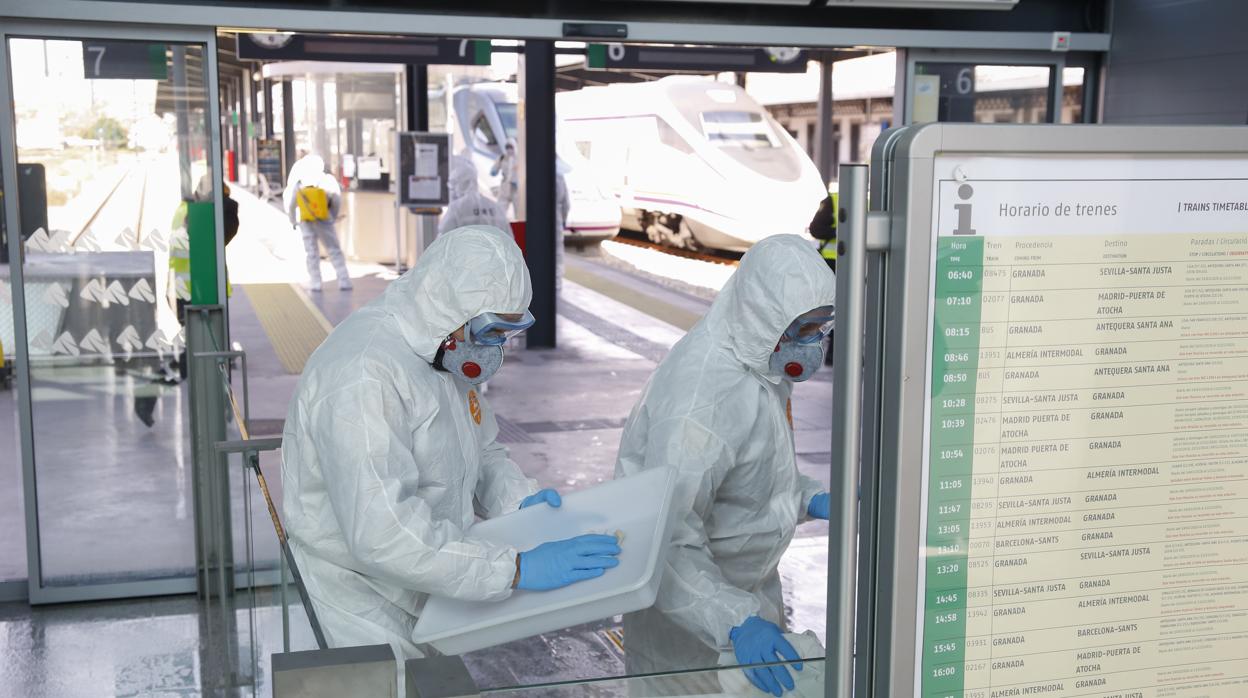 Dos miembros de la UME llevan a cabo la desinfección de una estación en Granada