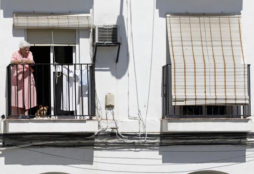 Una mujer mayor, en un balcón junto a la plaza del Pocito
