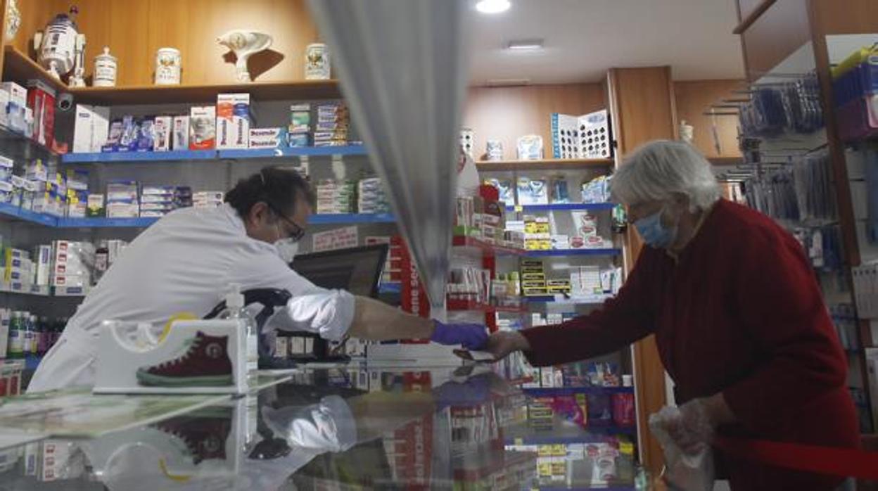 Un farmacéutico atiende a una clienta en Sevilla