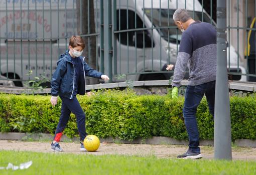 Un padre juega con su hijo en el parque Juan Carlos I