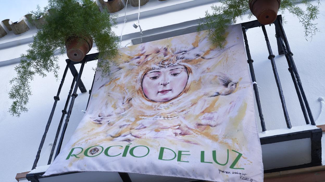 Uno de los balcones del recorrido luce la colgadura conmemorativa realizada por la Hermandad Matriz