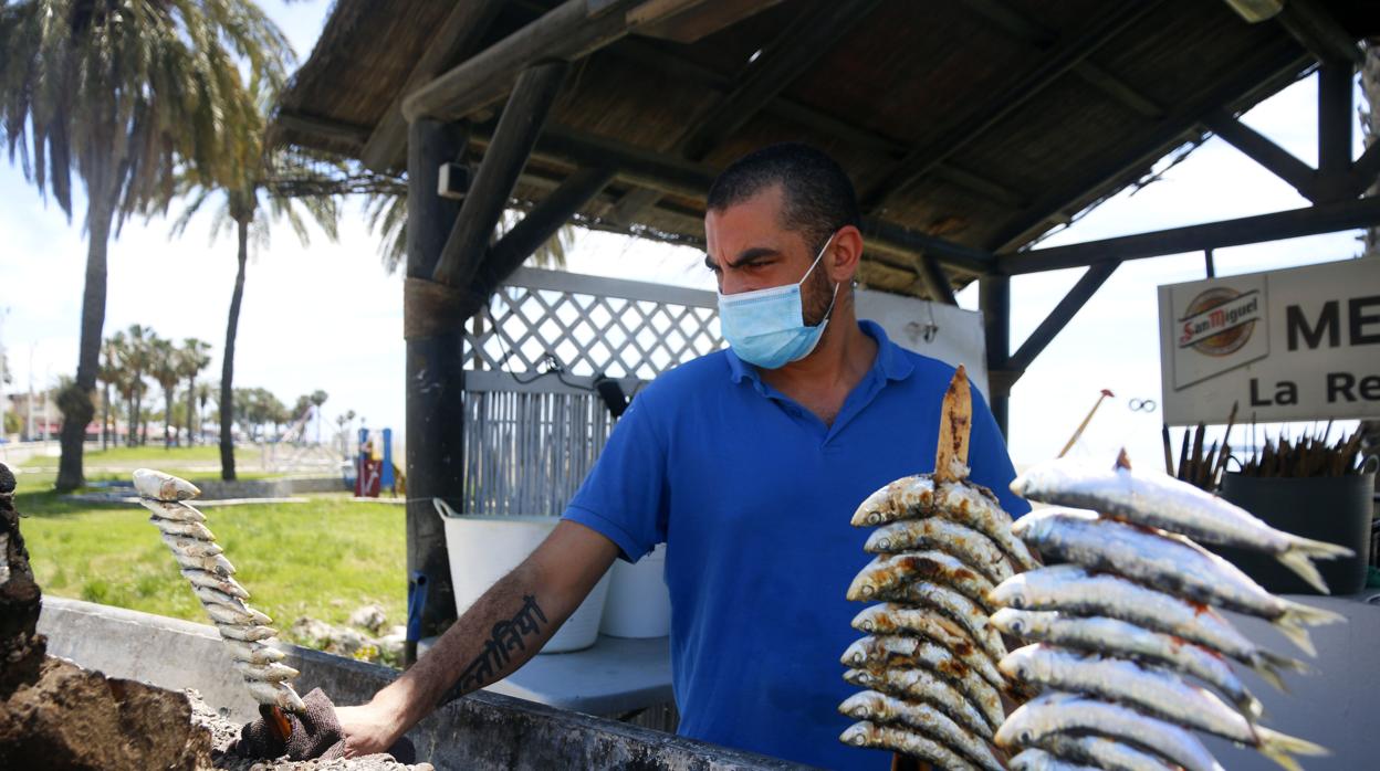 Un espetero prepara sardinas en las playas de Pedregalejo en Málaga