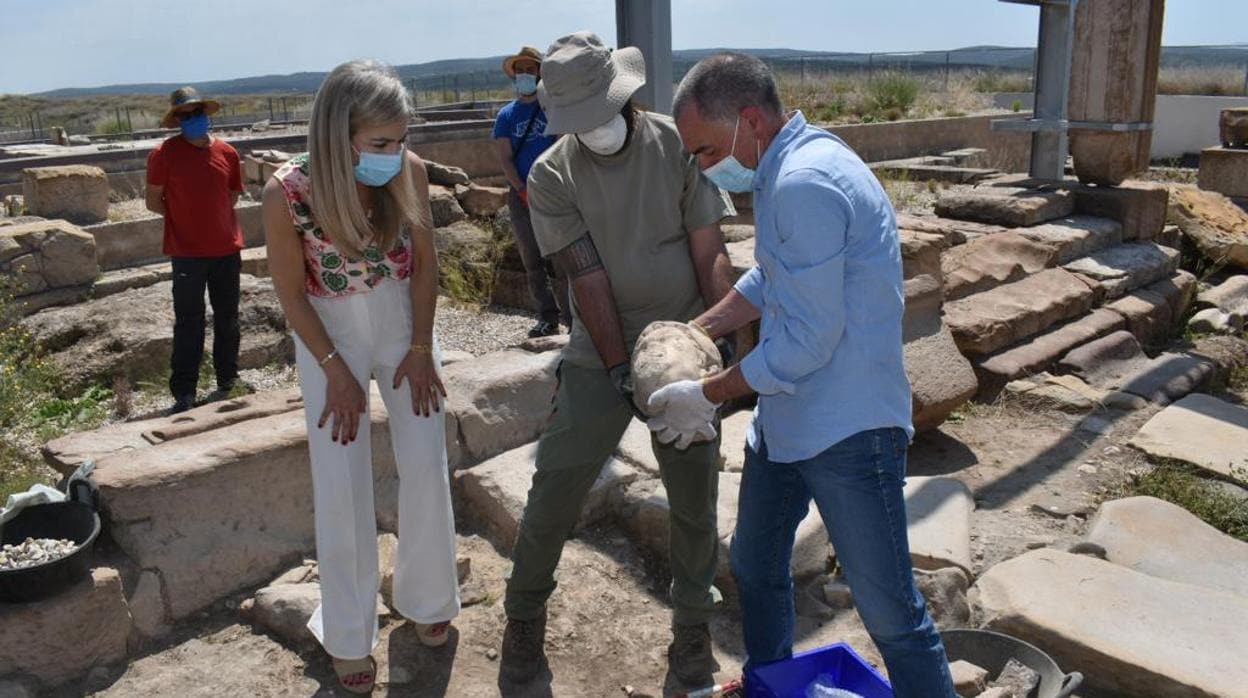 La consejera de Cultura observa la cabeza de mármol recién desenterrada