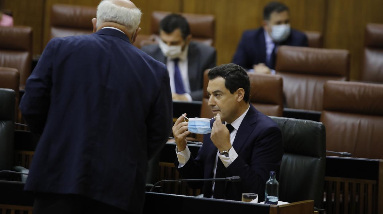 El presidente andaluz poniéndose la mascarilla para hablar con el consejero de Salud, Jesús Aguirre