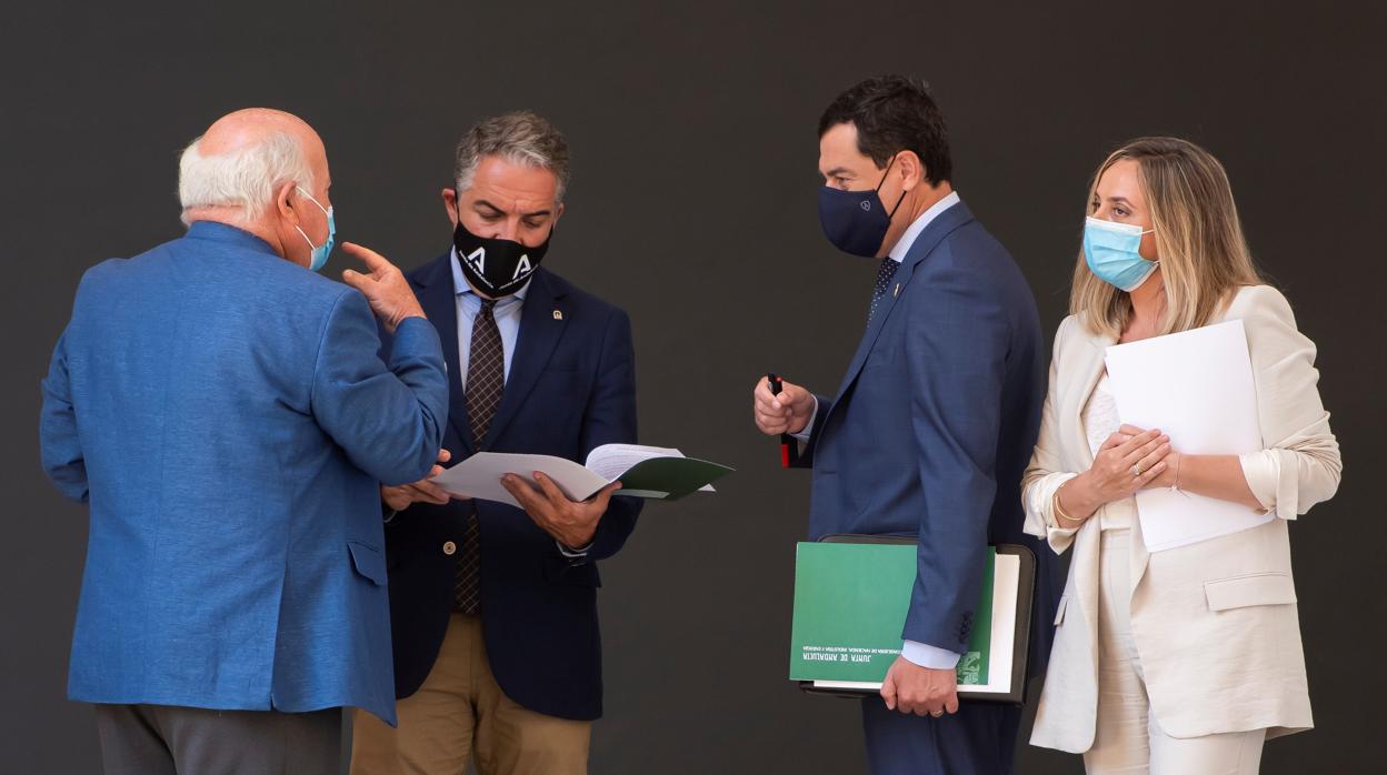 El presidente de la Junta de Andalucía, Juanma Moreno, charla con los consejeros Jesús Aguirre, Elías Bendodo y Marifrán Carazo tras el Consejo de Gobierno