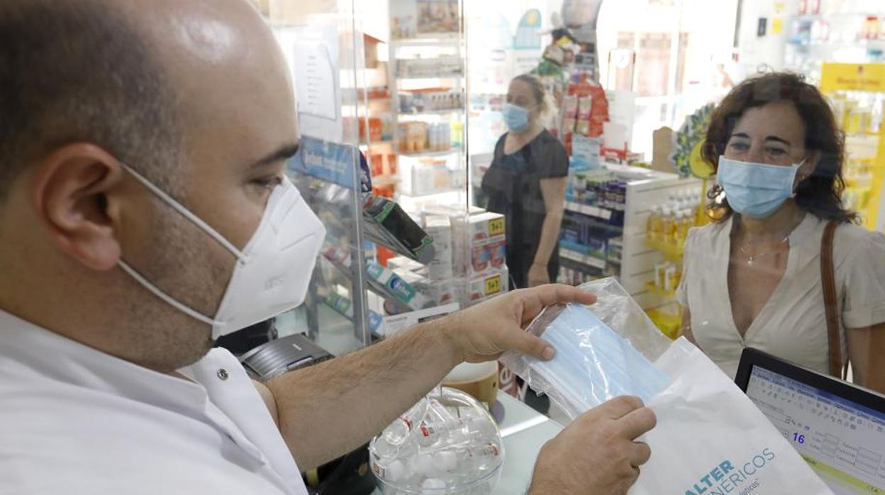 Una mujer compra mascarillas en una farmacia de Córdoba