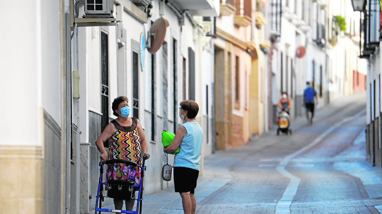 Dos mujeres conversan en una calle de La Rambla, el pueblo más golpeado por la oleada de positivos