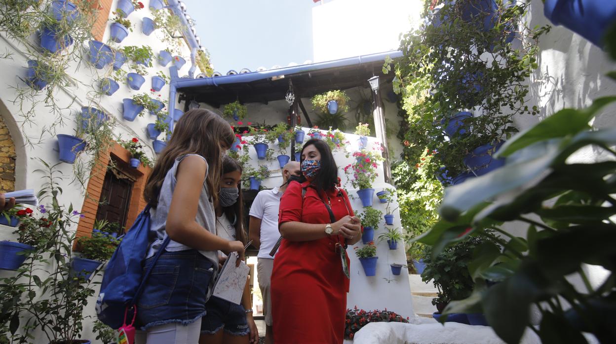 Una familia visita el patio de la calle Postrera, en el barrio de San Basilio de Córdoba