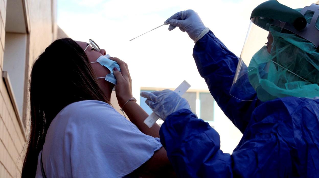 Un sanitario realiza una PCR a una mujer