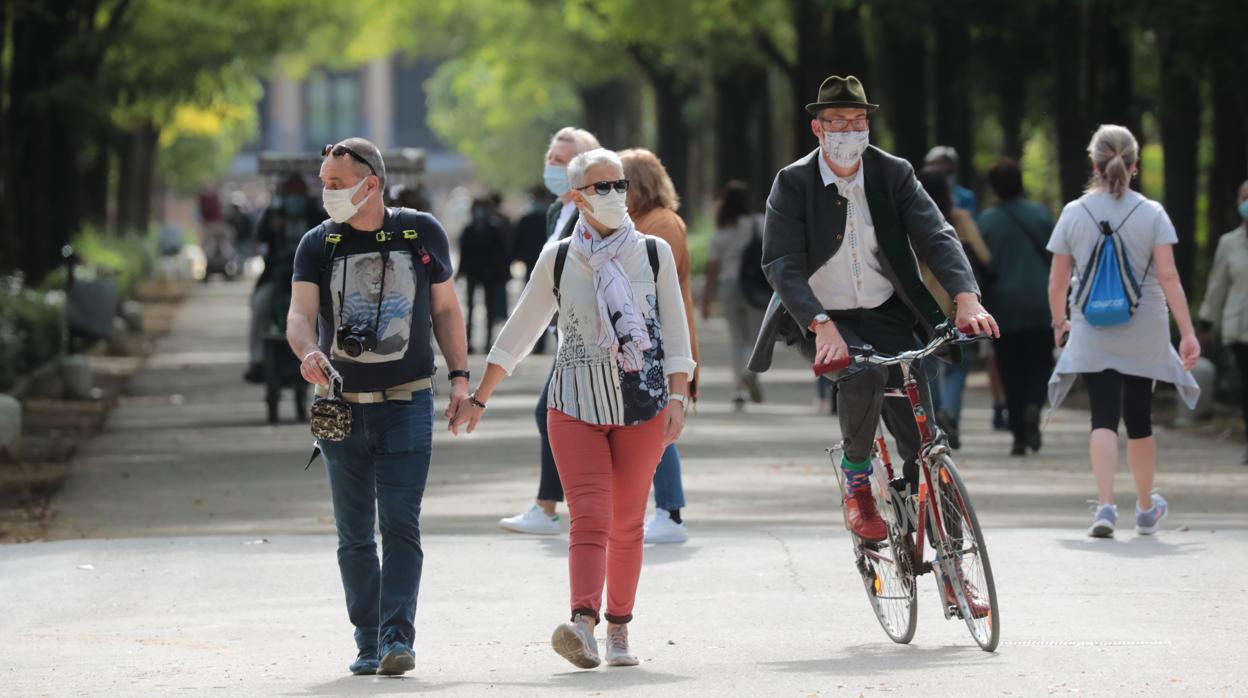 Varias personas pasean por el parque de María Luisa de Sevilla