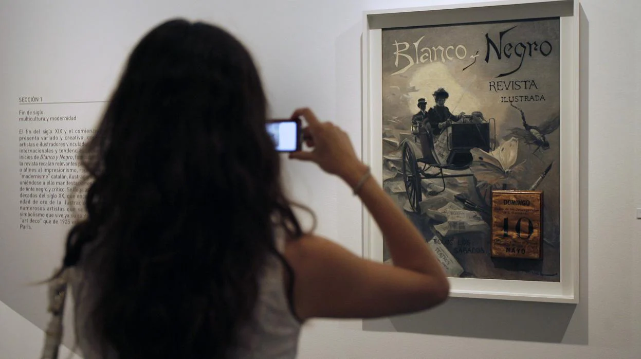 Una joven fotografía la primera portada de Blanco y Negro, en una exposición celebrada en Vimcorsa en 2011