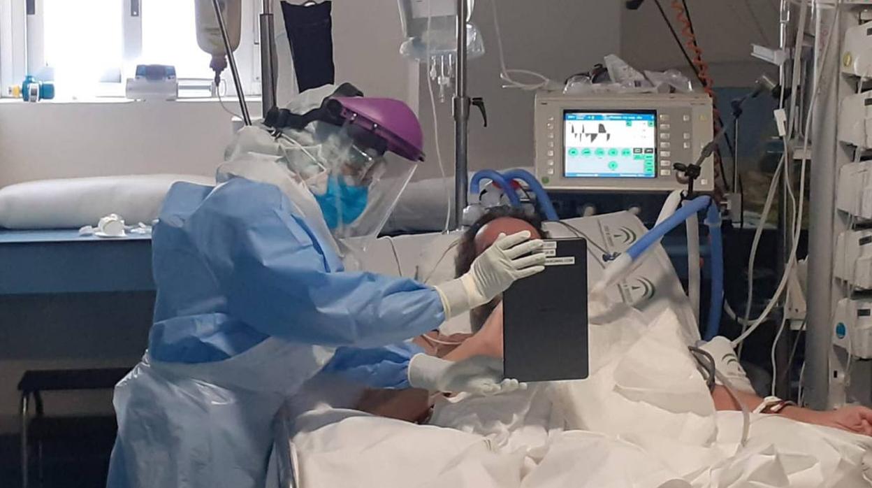 Un sanitario atiende a un paciente ingresado