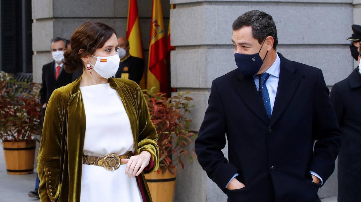 La presidenta madrileña, Isabel Díaz Ayuso y el presidente de la Junta de Andalucía, Juanma Moreno, a su llegada este domingo al Congreso de los Diputados