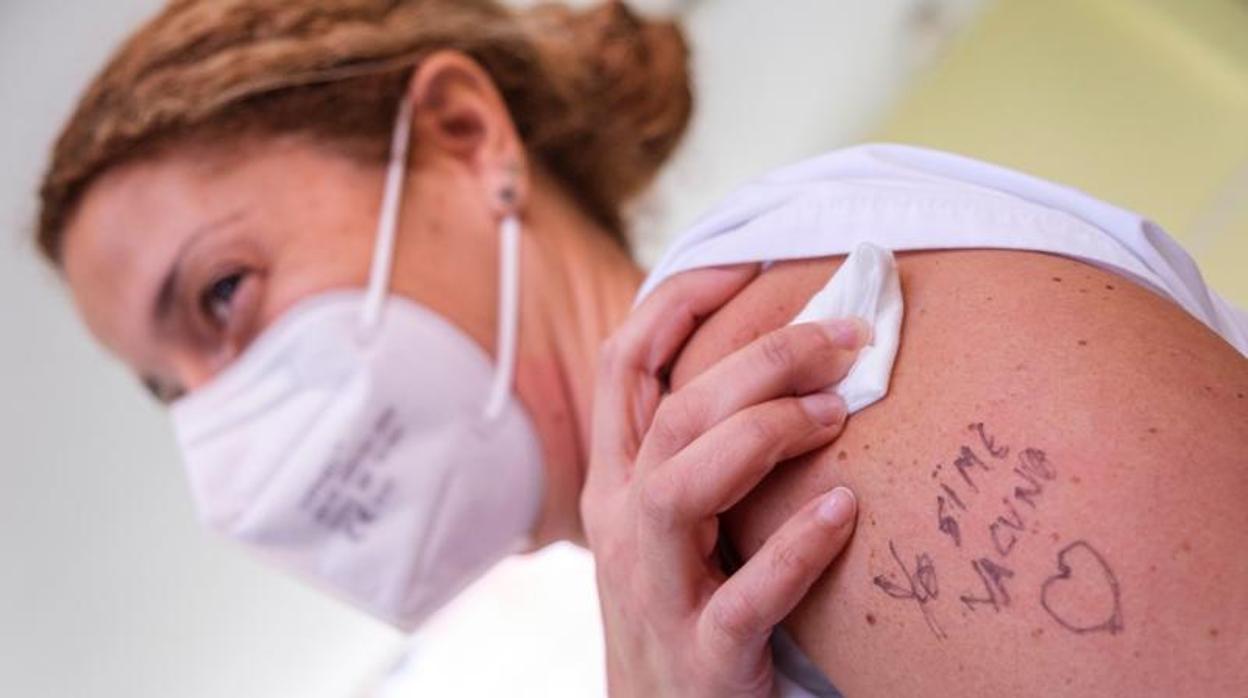 Una enfermera muestra en su brazo un «Yo sí me vacuno», escrito por su compañera, después de que ambas recibieran su primera dosis el lunes 11 de enero