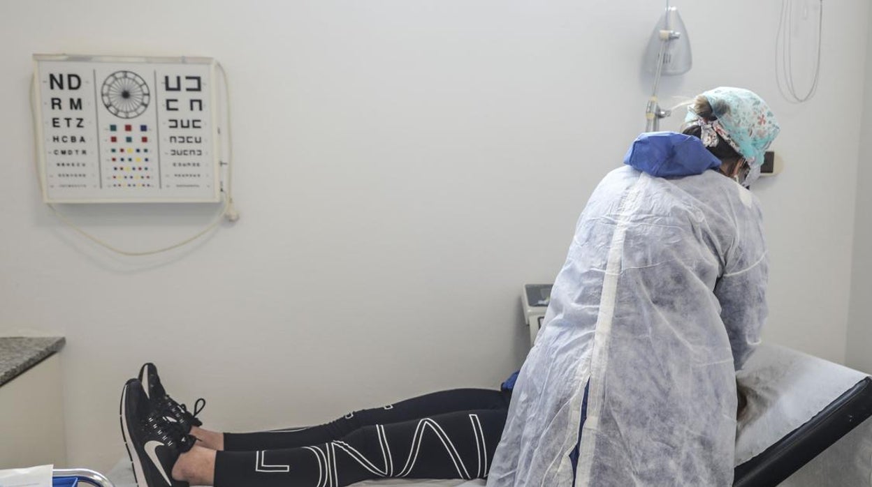 Una sanitaria atendiendo a un paciente