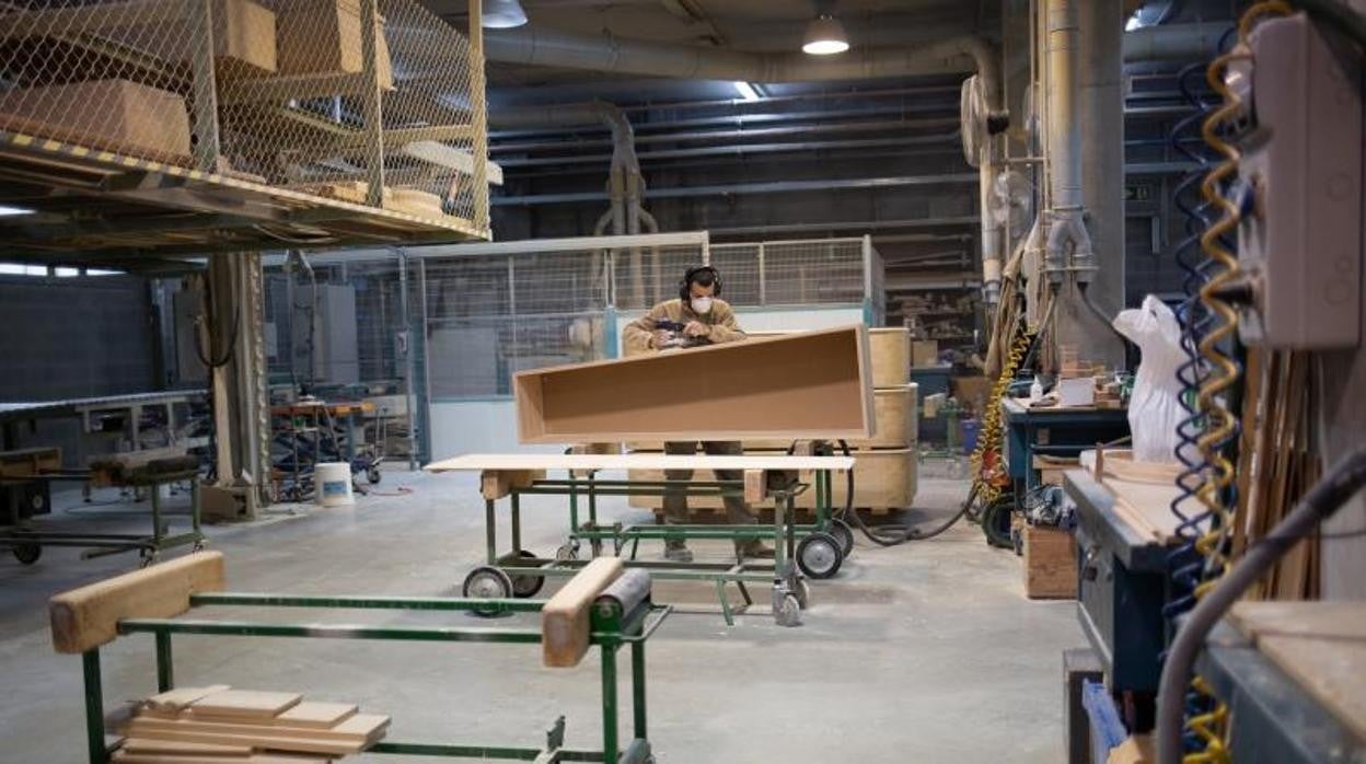 Un empleado trabaja fabricando un ataúd en una foto de archivo