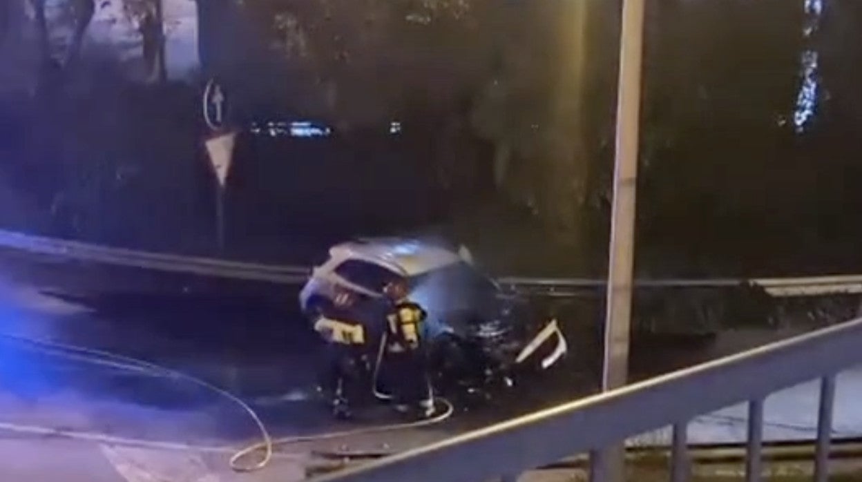 Los bomberos enfrían el coche de la británica después de ser abandonado tras el impacto