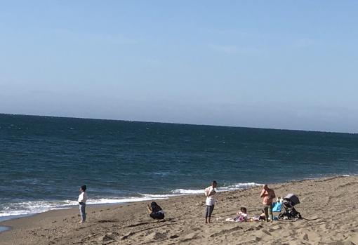 Dos chicas se sacaban fotos en la playa junto a una familia en la arena de Fuengirola