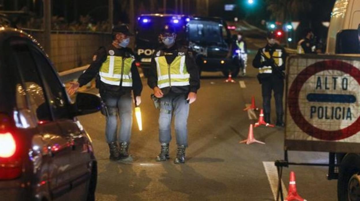 Dos policías realizan un control por la noche para controlar el toque de queda
