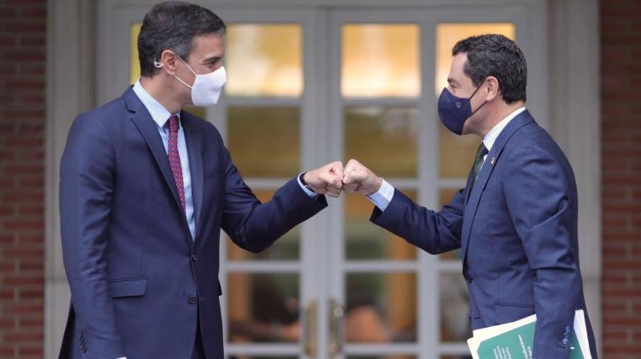 El presidente del Gobierno, Pedro Sánchez, saluda con el puño al presidente andaluz, Juanma Moreno, en la Moncloa