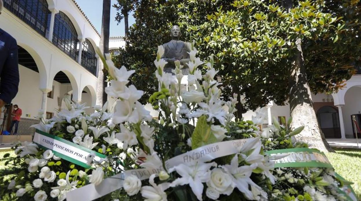 Los ramos de flores a los pies del busto de Blas Infante en el patio principal del Parlamento andaluz