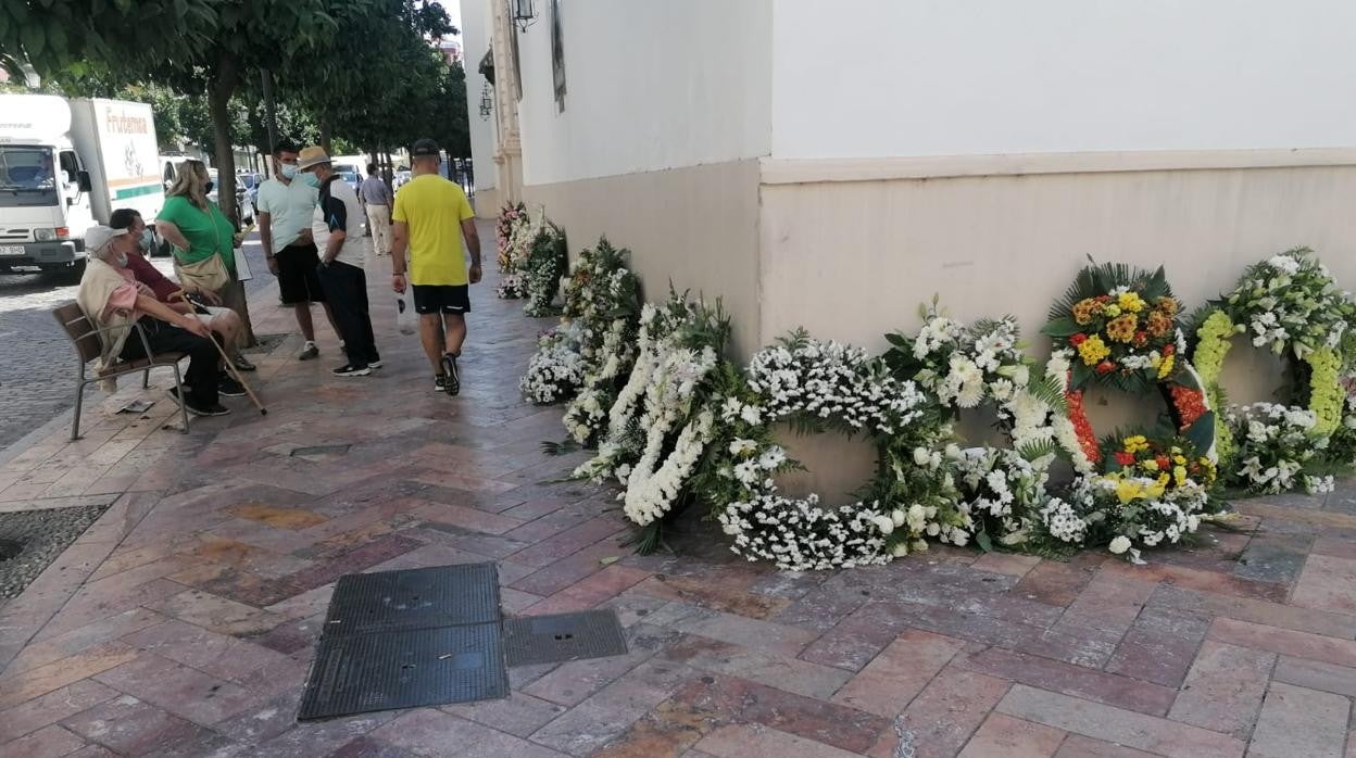 Coronas de flores rodean la iglesia en la que se ha celebrado el funeral de Hugo Millán