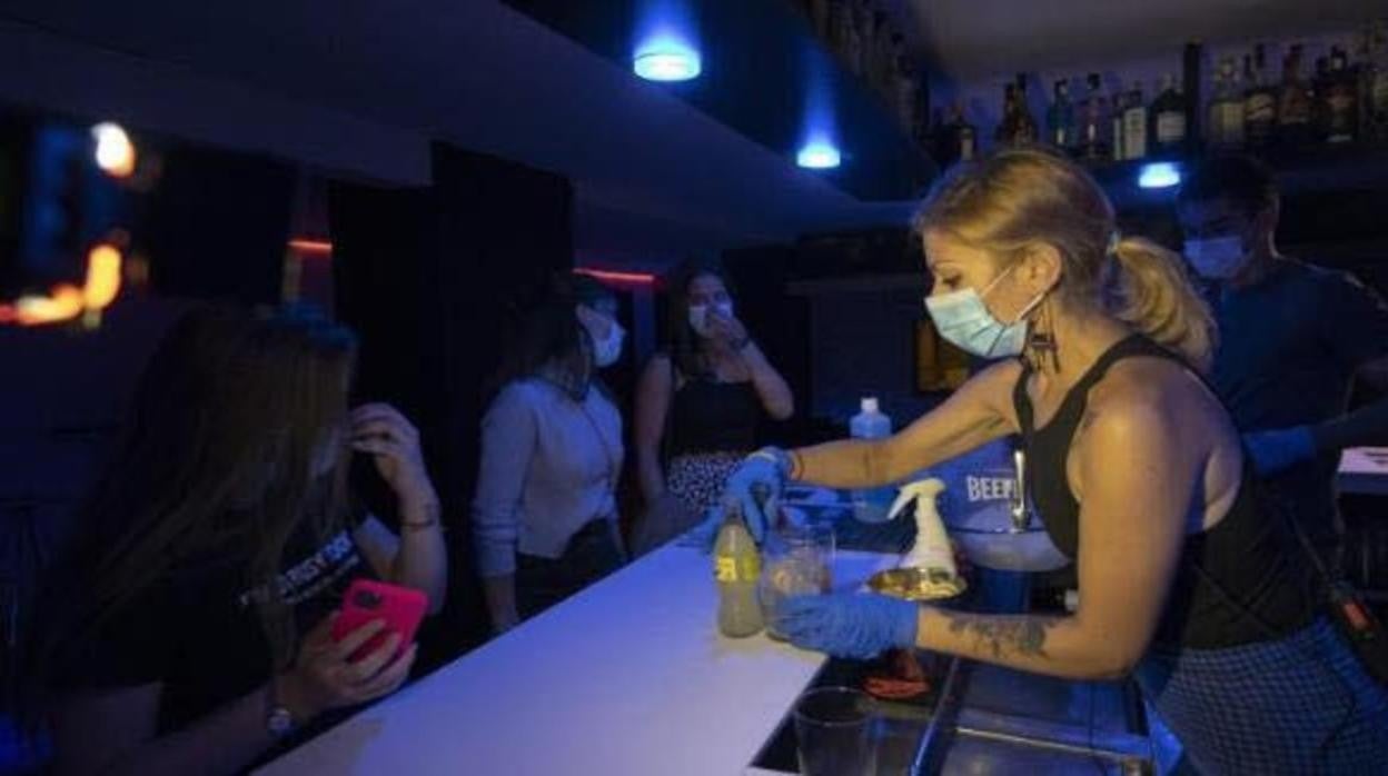 Una camarera y unas clientas en un bar de copas de Cádiz